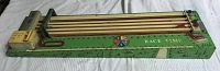 Full view of the vintage mechanical toy race game showing wooden lanes, spinner, and green painted board.