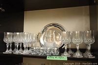 The full lot contents showing 27 crystal wine glasses in Longchamp pattern, 8 liqueur glasses, glass decanter, and silver serving tray