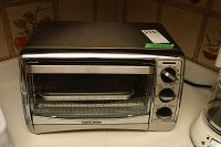 Front view of Black and Decker toaster oven showing controls and brand logo.