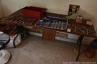 View of MDF collapsible table with multiple hand tools displayed on top, including wrenches, clamps, and a red toolbox.