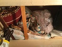 Photo of folded woven rugs, blankets and packaged fabric items in a storage cubby