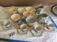 Photo showing Lefton china creamer, sugar bowl, demitasse cups with saucers, and assorted teacups arranged on a surface