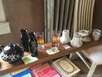 Side view of lot items including Hamilton Cross teapot, two hand-painted vases, glasses, white candle holders, ceramic flowers, and mugs.