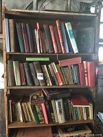 Full bookshelf showing multiple rows of vintage books, some with worn spines and faded covers.