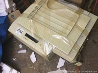 Full view of Panasonic FP-1270 commercial printer on floor, wrapped in plastic, showing paper trays and top control panel.