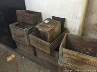 Photo showing several old wooden crates stacked together with visible brand names Borden's, Western Cartridge.