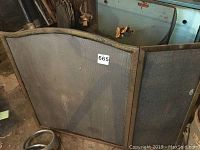 Three fireplace screens shown leaning against the wall. Screens are black/bronze with mesh and metal framing, one with a curved top and some rust and wear visible.