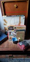 Photo showing a collection of vintage games and children's books stacked together including Skill-Tile board game box, old magazines, and some game pieces in bags and box.