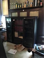 Full view of oak lawyer's cabinet with three sections, glass fronts, shelves inside, and wooden frame in dark oak finish.