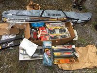 Overview of assorted skiing gear salesman samples including ski bag, various new packaged accessories.