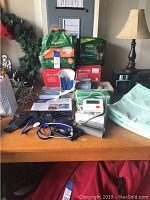 Wide view of lot on table showing blood pressure monitors, stethoscope, packages of gloves, adult diapers, underpads and first aid supplies.