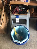 Step stool with box on top containing Dirt Devil vacuum hardware and a blue collapsible bucket with a brush inside.