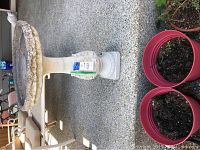 Photo of concrete bird bath showing its round basin, pedestal base, and repair work.