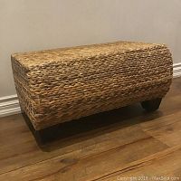 Front view of woven seagrass ottoman showing rectangular shape and wood floor