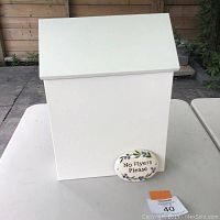 White metal mailbox with sloped roof and accompanying ceramic plaque with "No Flyers Please" text.