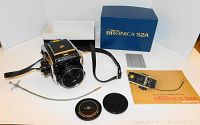 Full kit overview including camera body with lens, box, strap, cable, lens caps, manual and inserts