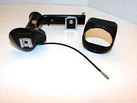 Black Hasselblad flash bracket with built-in hand grip and cable, plus circular flash holder attachment on a neutral background.