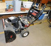 Side view of entire snow blower on workshop floor