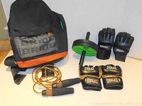 Boxing and exercise equipment arranged beside a black and orange backpack