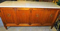 Front view of the buffet showcasing marble top and wooden cabinets with brass ring pulls