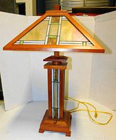 Full view of lamp showing wood frame, stained glass shade and base panels, yellow cord and pull-chain switch.
