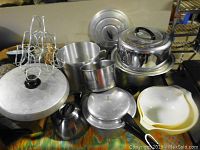 Overview of kitchen items including pots, pans, bowls, and wire holder to document lot content.