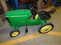 Left front quarter view showing body decals, front wheels and pedal assembly