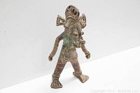 Front view of the metal African fertility statue showing detailed engravings and posture.