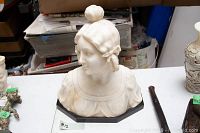 Front view of marble bust showing facial features and draped bodice