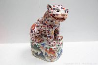 Front view of porcelain foo dog on rock base