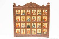 Full view of wooden frame with 20 icons arranged in grid showing religious figures from Greek Orthodox tradition.