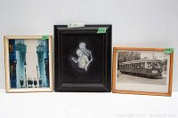Three framed vintage art pieces shown side by side: abstract cityscape painting, surreal skeleton and human figure painting, vintage streetcar photograph.