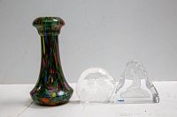 Full lot photo showing three items on white background: colored glass vase, maple leaf crystal paperweight, girl etched crystal paperweight