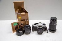 Wide shot showing Nikon FG camera body, three lenses, manual and boxes