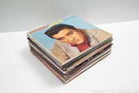 Stack of about 30 vinyl record albums featuring classic artists with wear on the covers.