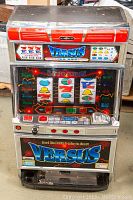 Front view of the slot machine showing graphic panels, reel symbols, and buttons.