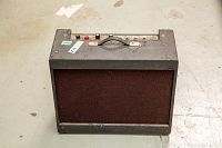 Front view of amplifier showing brown speaker grille and black textured covering.