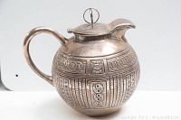Side view displaying handle, body and engraved geometric pattern
