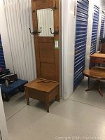 Full view of oak hall stand with mirror, hooks, and storage bench base.