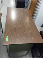 Top view of metal desk with wood grain laminate top