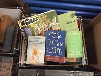 Box showing a variety of nonfiction and fiction books including history, grammar, and novels, visible titles include 'The White Cliffs,' 'A History of the English Church and People,' 'Gell's Grammar,' and 'Glamorgan'