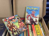 Open box showing vintage hardcover annual books including Roy Rogers Cowboy Annual and Zip Annual