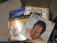 Box with visible album covers: Billy Joel, Elvis Presley, BJ Thomas, The Parachute Club