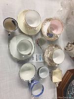 Top-down view showing all tea cups and saucers in the lot arranged on a table surface