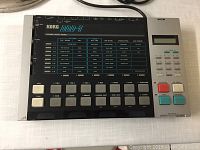 Top view of the Korg DDD-1 drum machine showing multiple labeled buttons and controls for digital drum sounds and pattern editing.