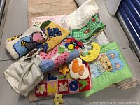 Full overview of various vintage kids' blankets, quilts, and a baby mobile piled together