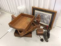 Overview of wooden file holders, framed print, wooden statue, decorative box, brass lamp and candle snuffer