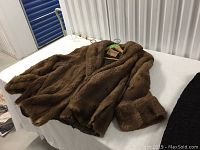 Brown fur jacket laid flat showing texture and condition.