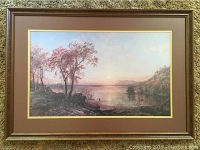 Full view of framed print showing landscape with small boat and people on shore under sky, surrounded by brown and gold matte and ornate wood frame.