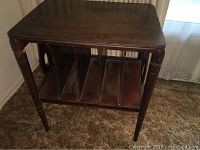 Front angled view of the table showing record storage compartments and legs.